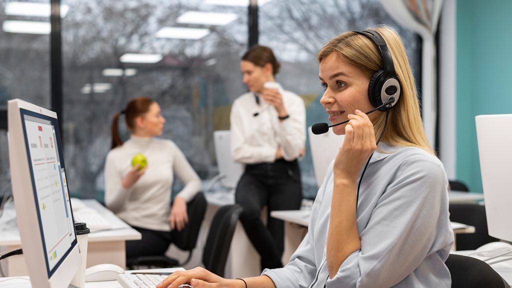 Mujer trabajando en un call center utilizando Dynamics 365 Contact Center para la gestión de clientes.